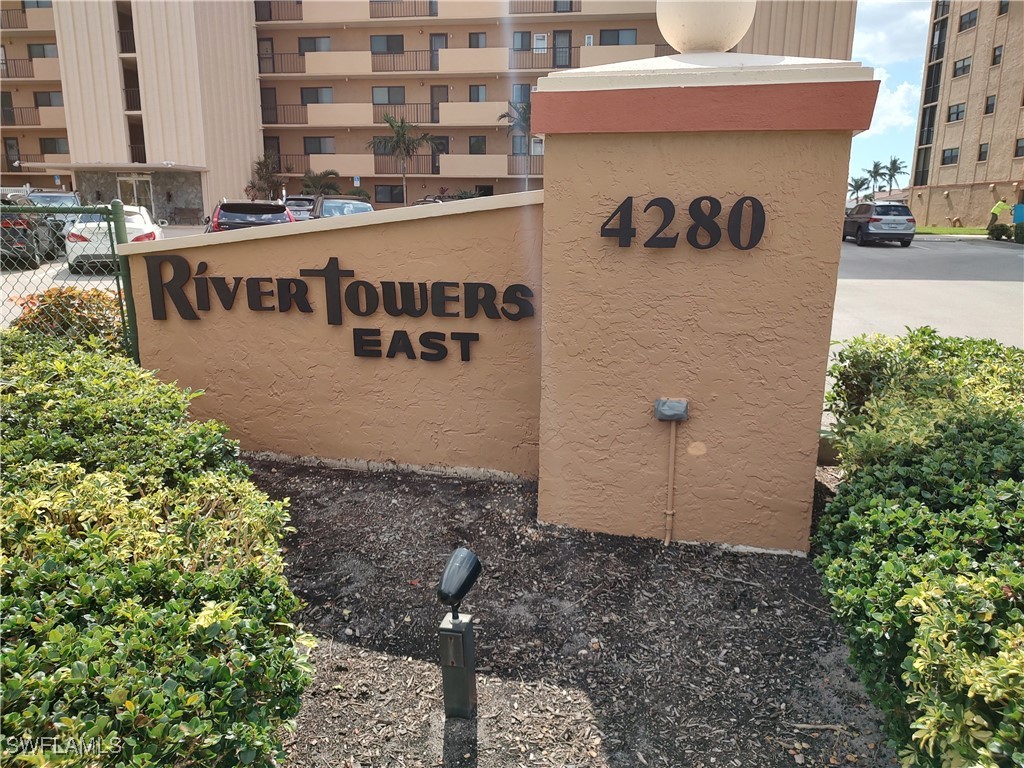 a sign board with buildings in the background