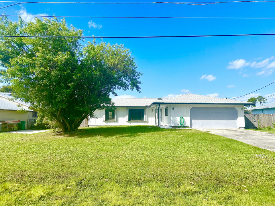 a view of a house with a yard and a garage