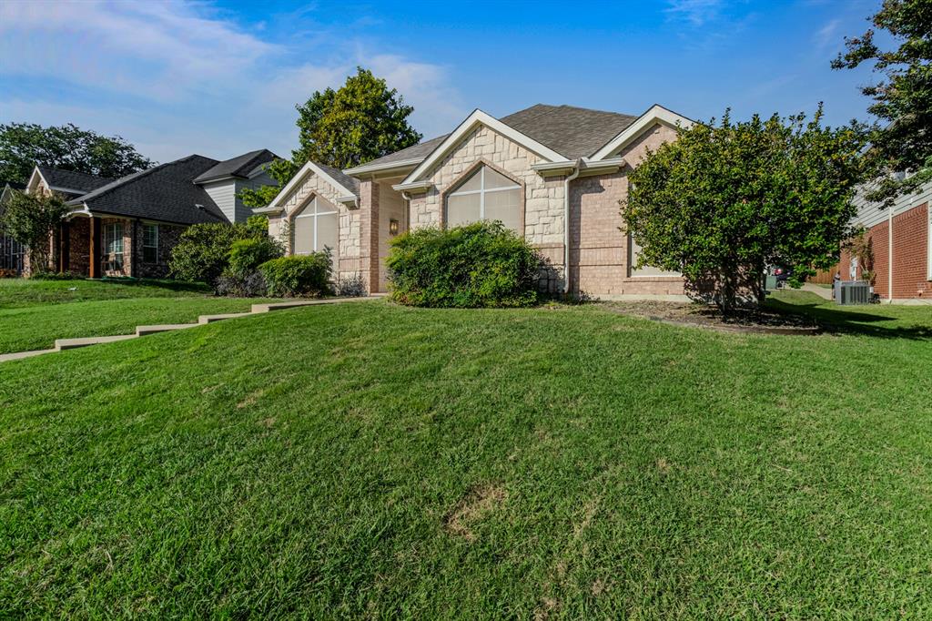 a front view of a house with a yard and trees