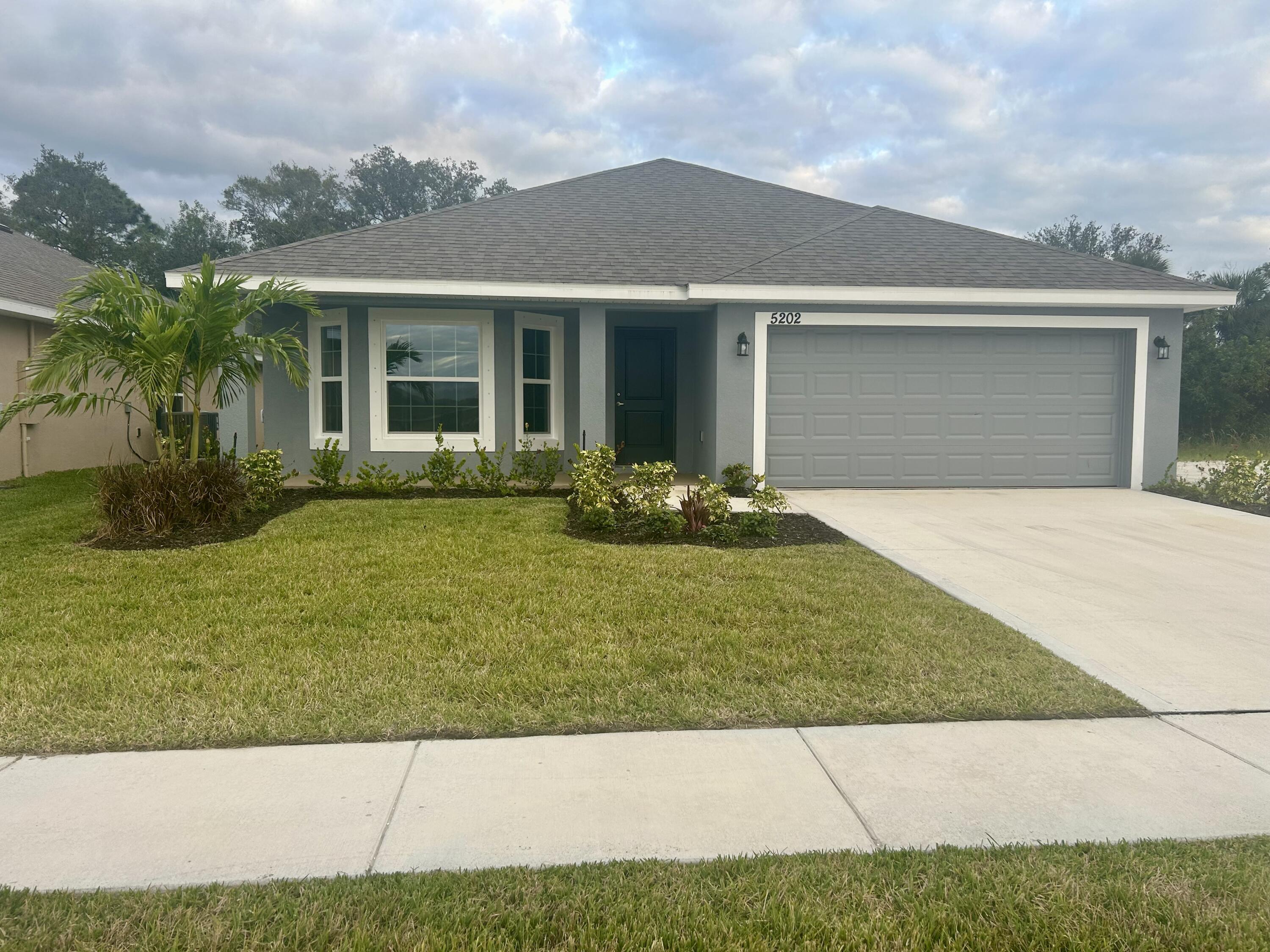 a front view of a house with a garden and yard