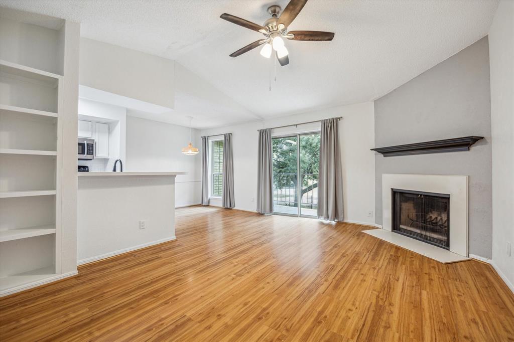 Spacious living room with vaulted ceiling, bathed in natural light with large sliding door and full length window.