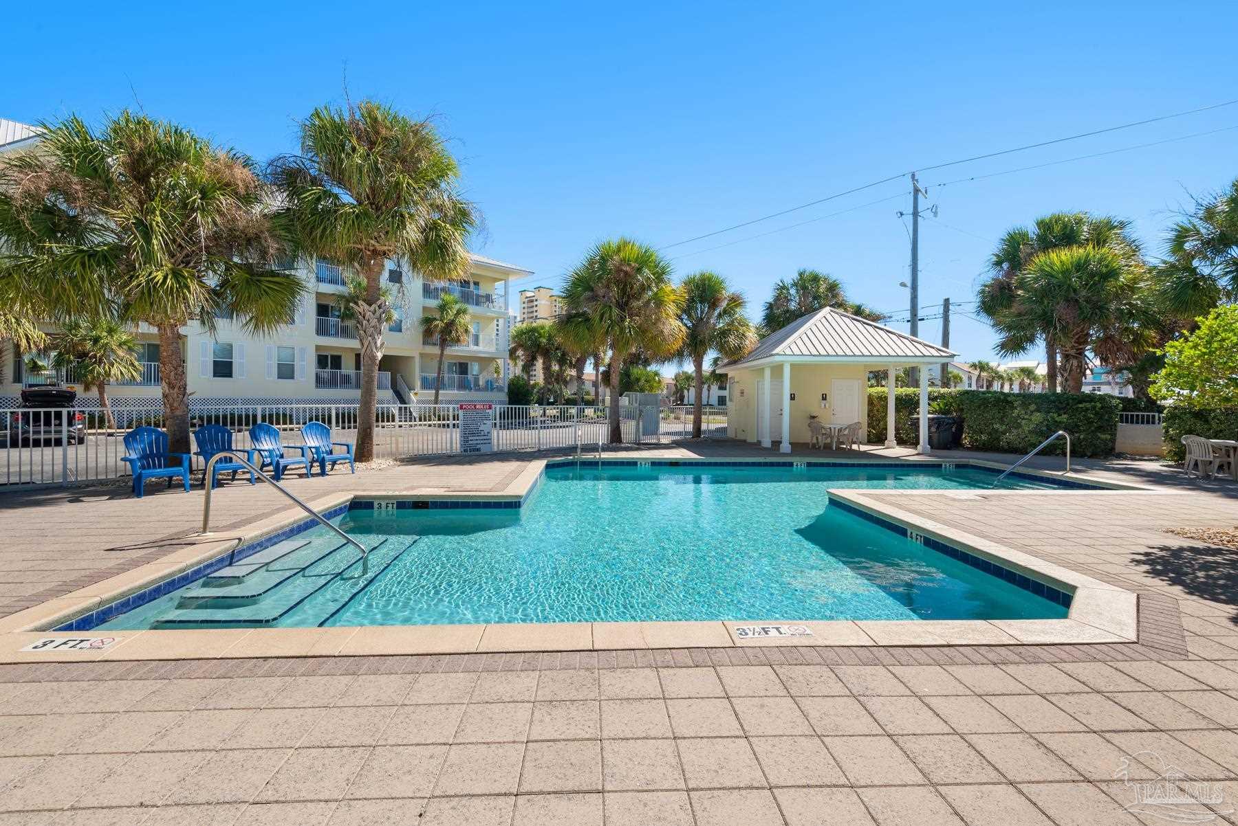 a view of a house with a swimming pool and sitting area