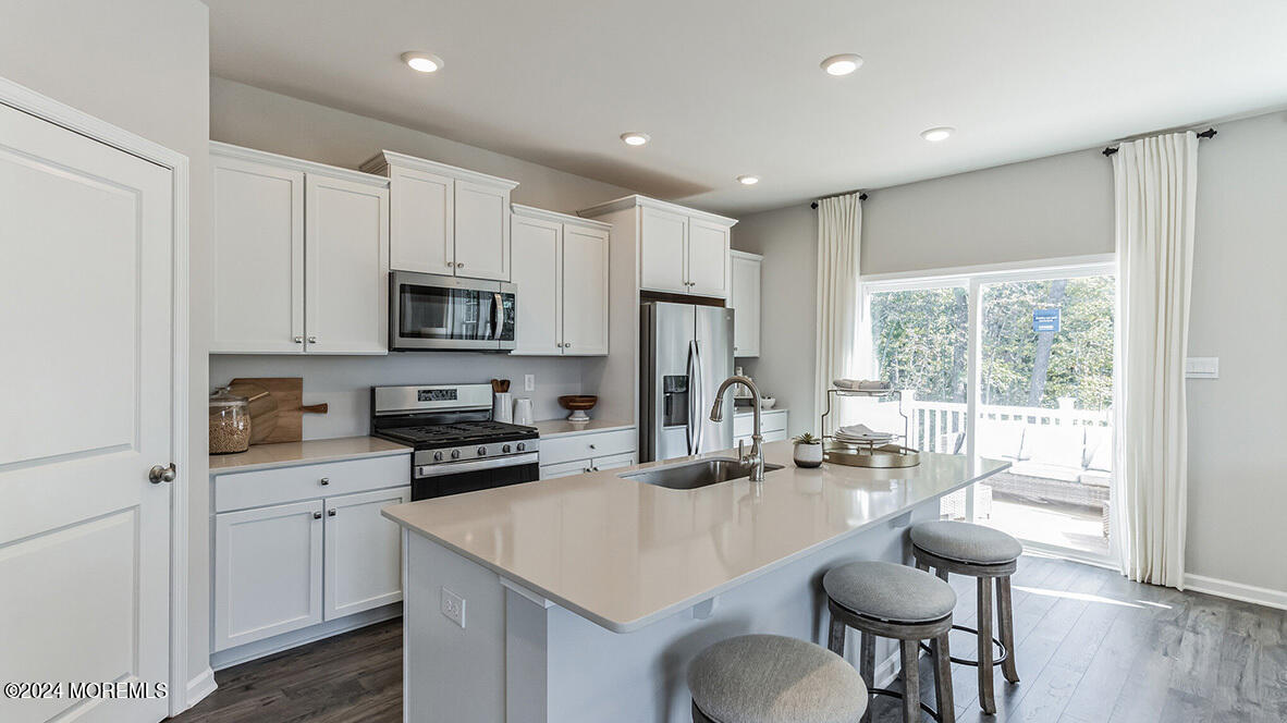 a kitchen with sink a microwave and cabinets