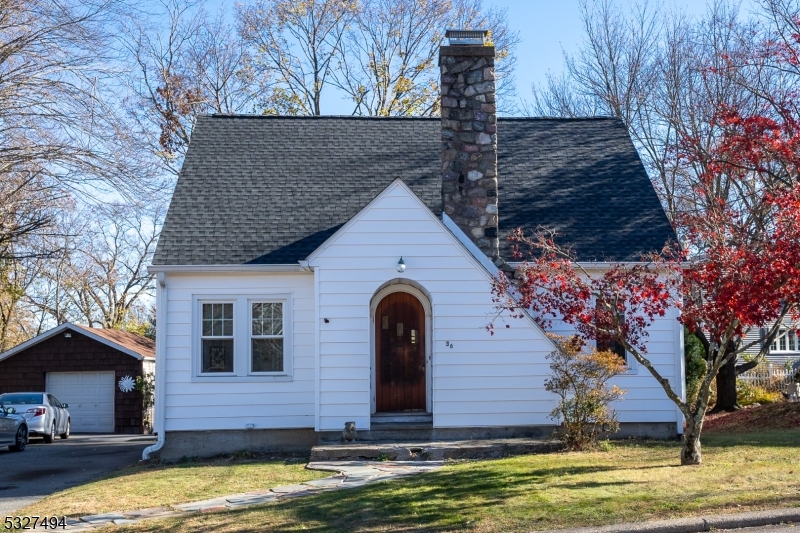 a front view of house with yard and trees in the background