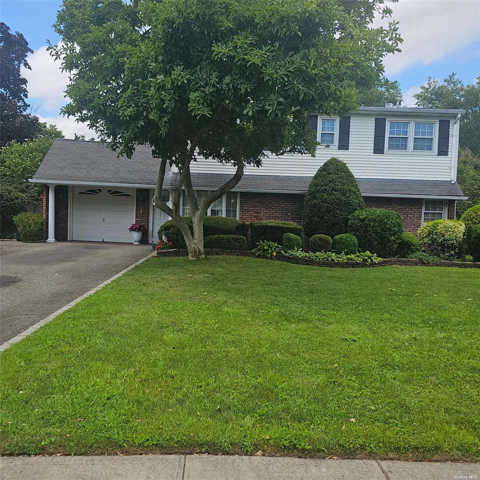 a front view of a house with a yard and trees