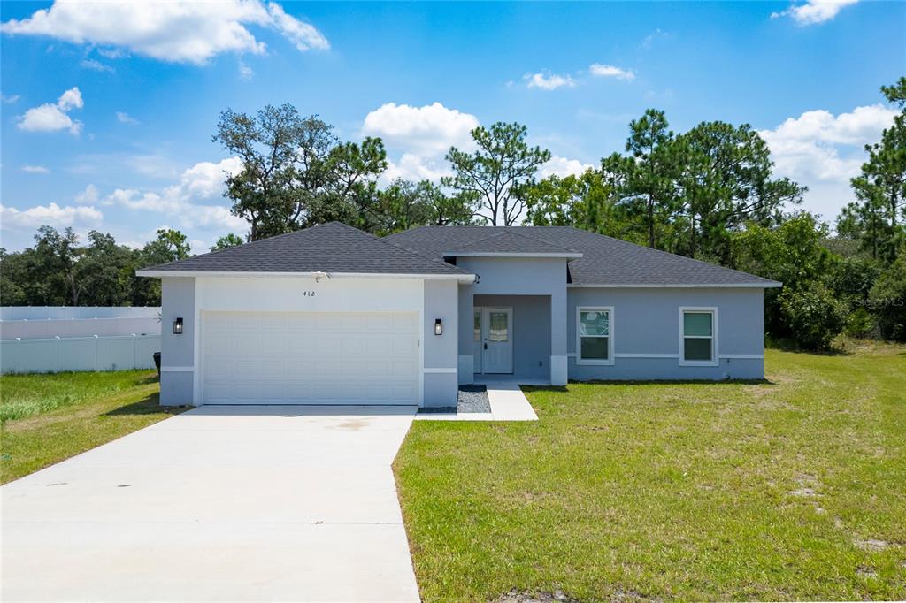 a front view of a house with yard and garage