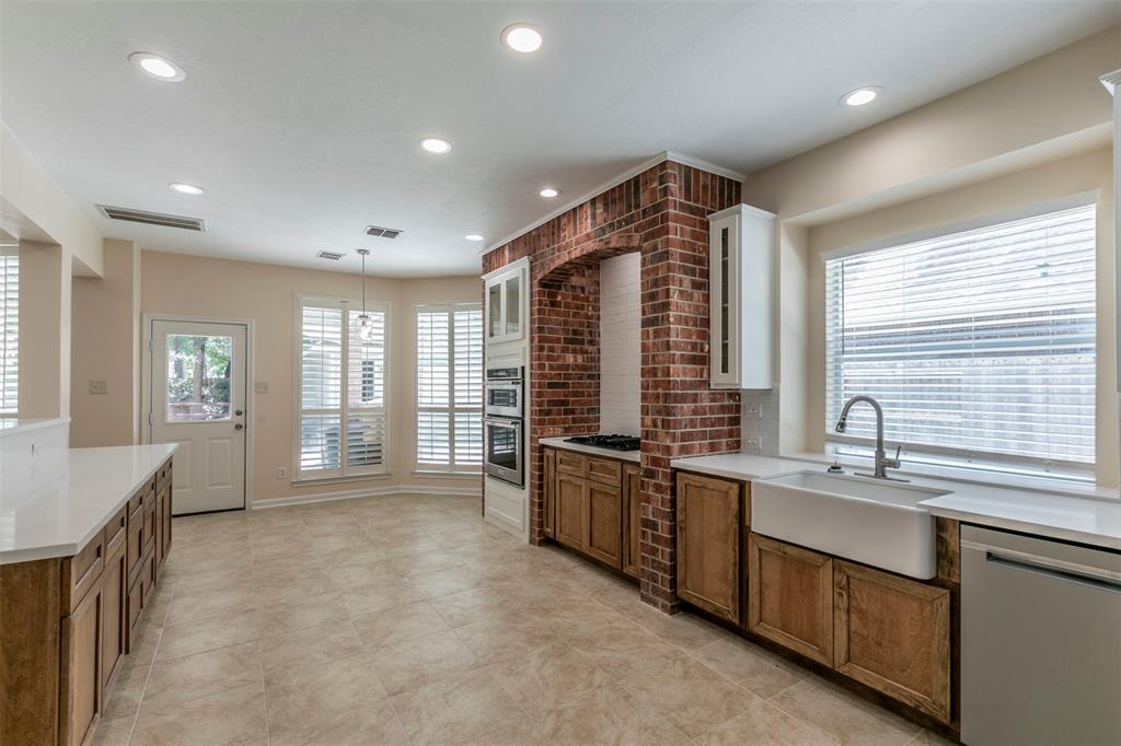 a large kitchen with stainless steel appliances granite countertop a lot of counter space and a sink