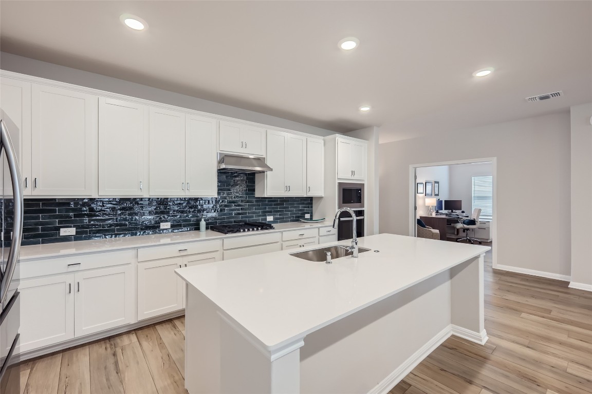 a kitchen with a sink a stove and cabinets