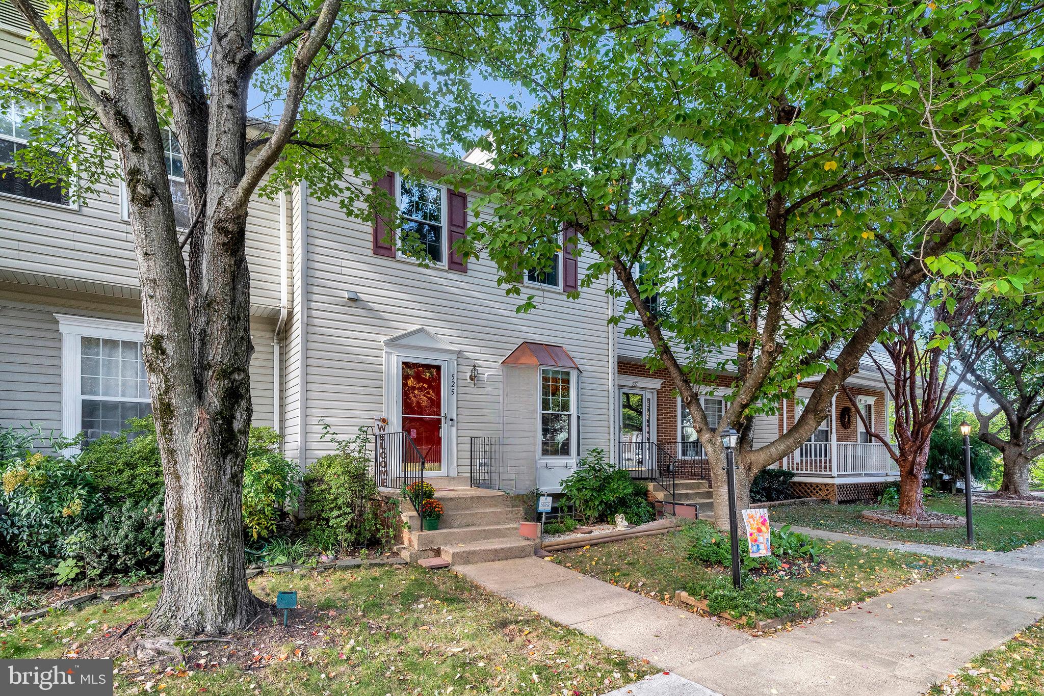 a front view of a house with a yard and tree