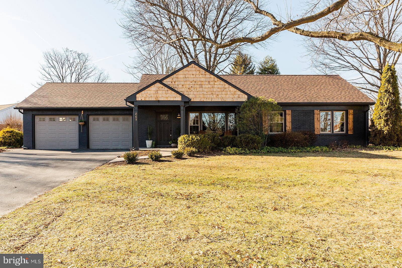 a front view of a house with a yard and trees