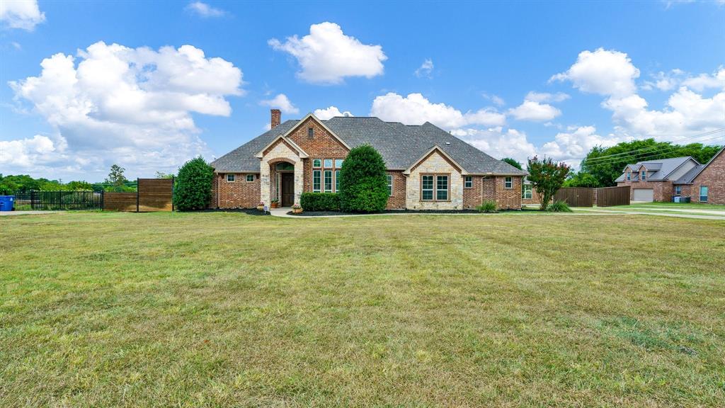 a view of a house with a big yard and large trees