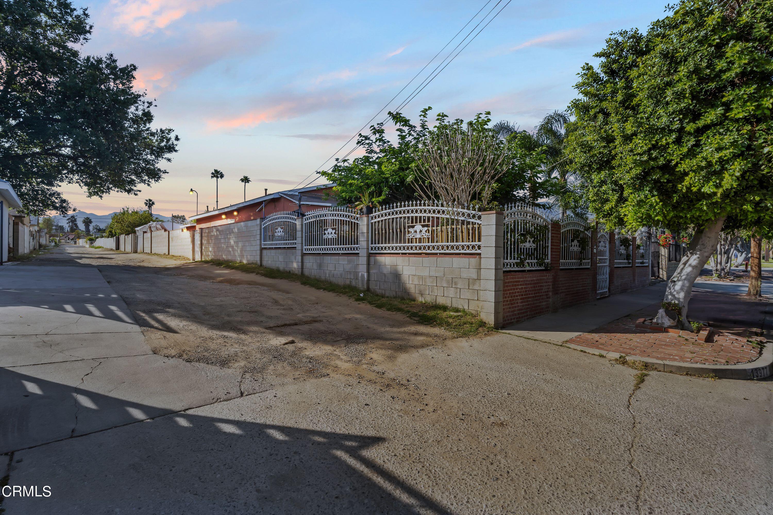 a view of a brick house with many windows next to a road