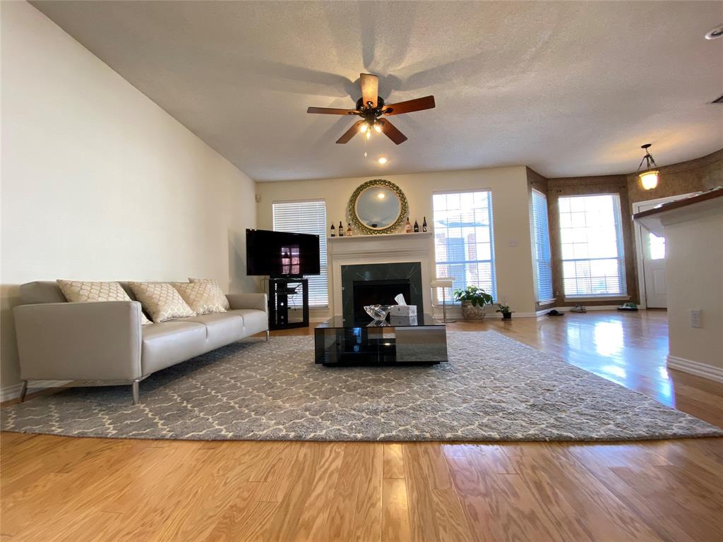 a living room with furniture a fireplace and a large window