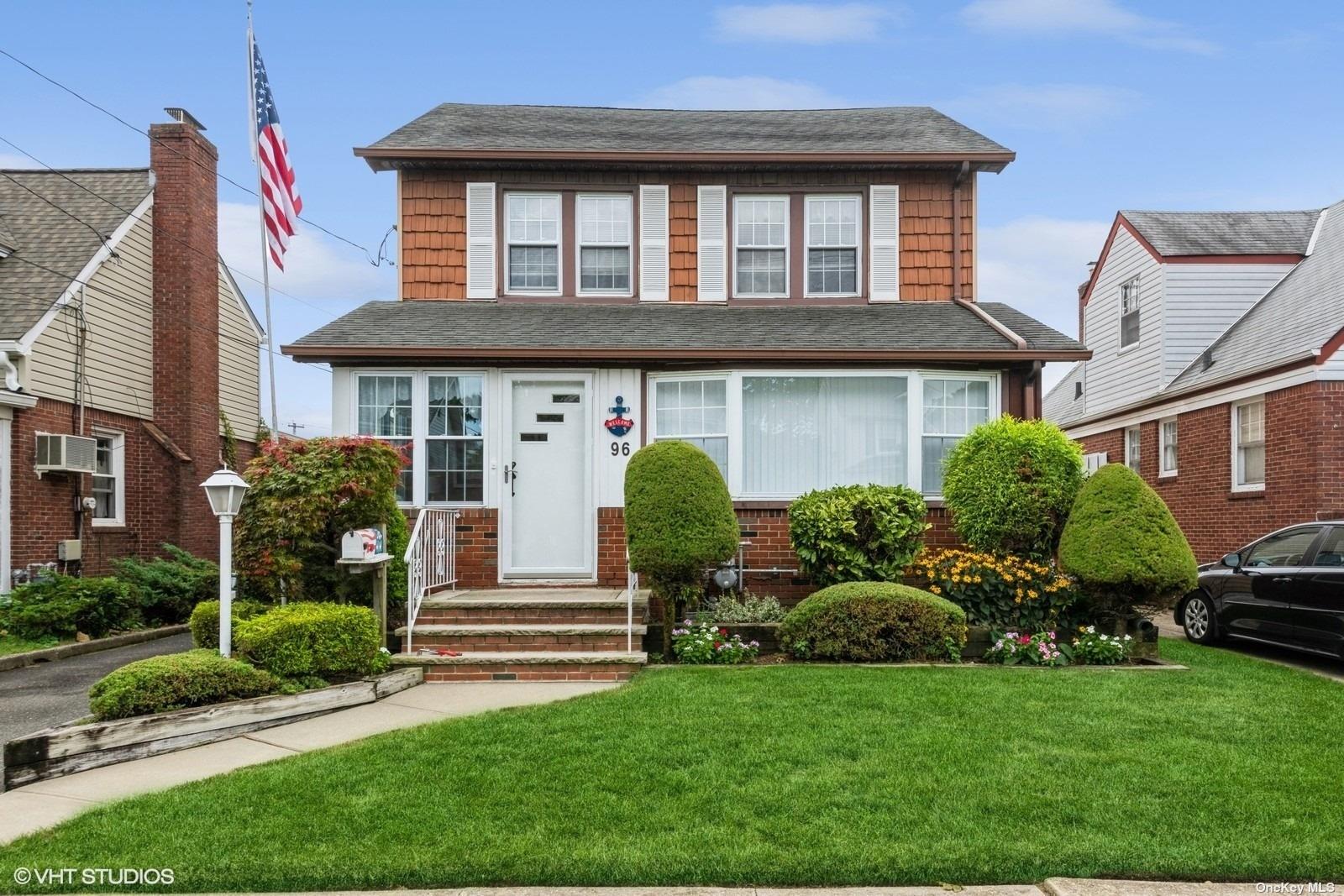 a front view of a house with garden and plants