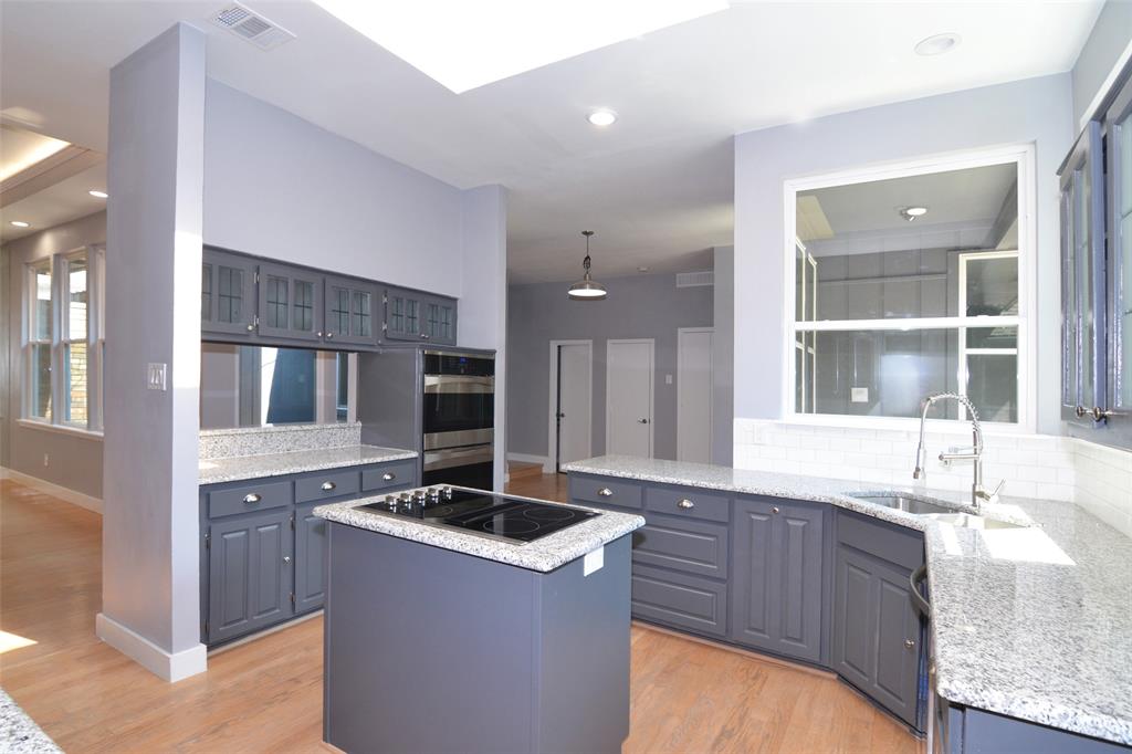 a kitchen with granite countertop a sink and white cabinets