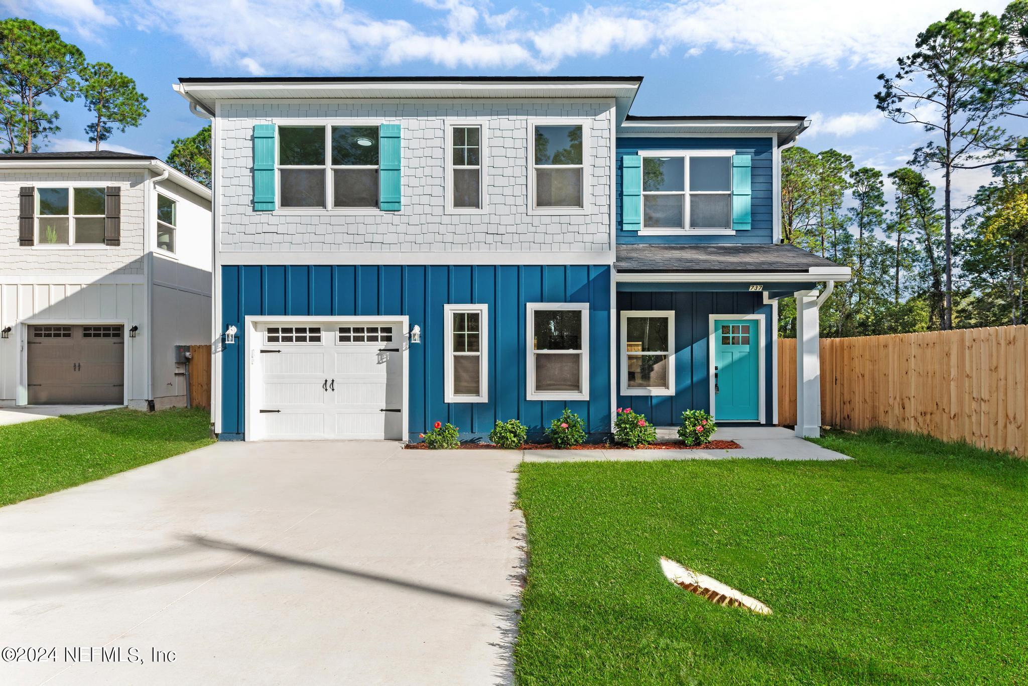 a front view of a house with a yard and trees