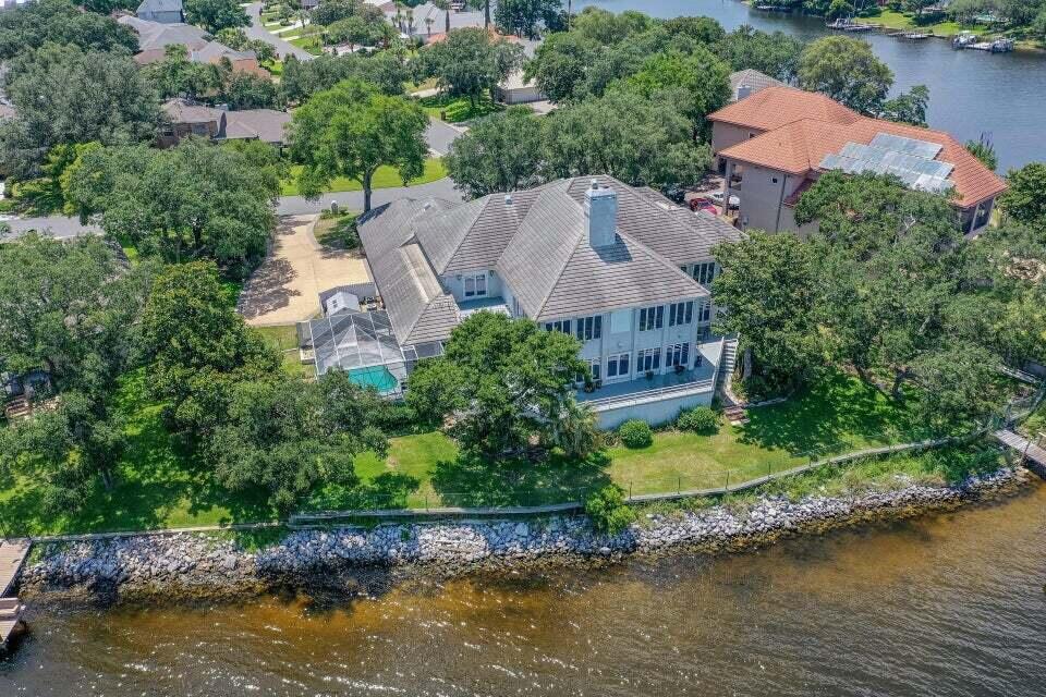 an aerial view of a house with a garden and lake view