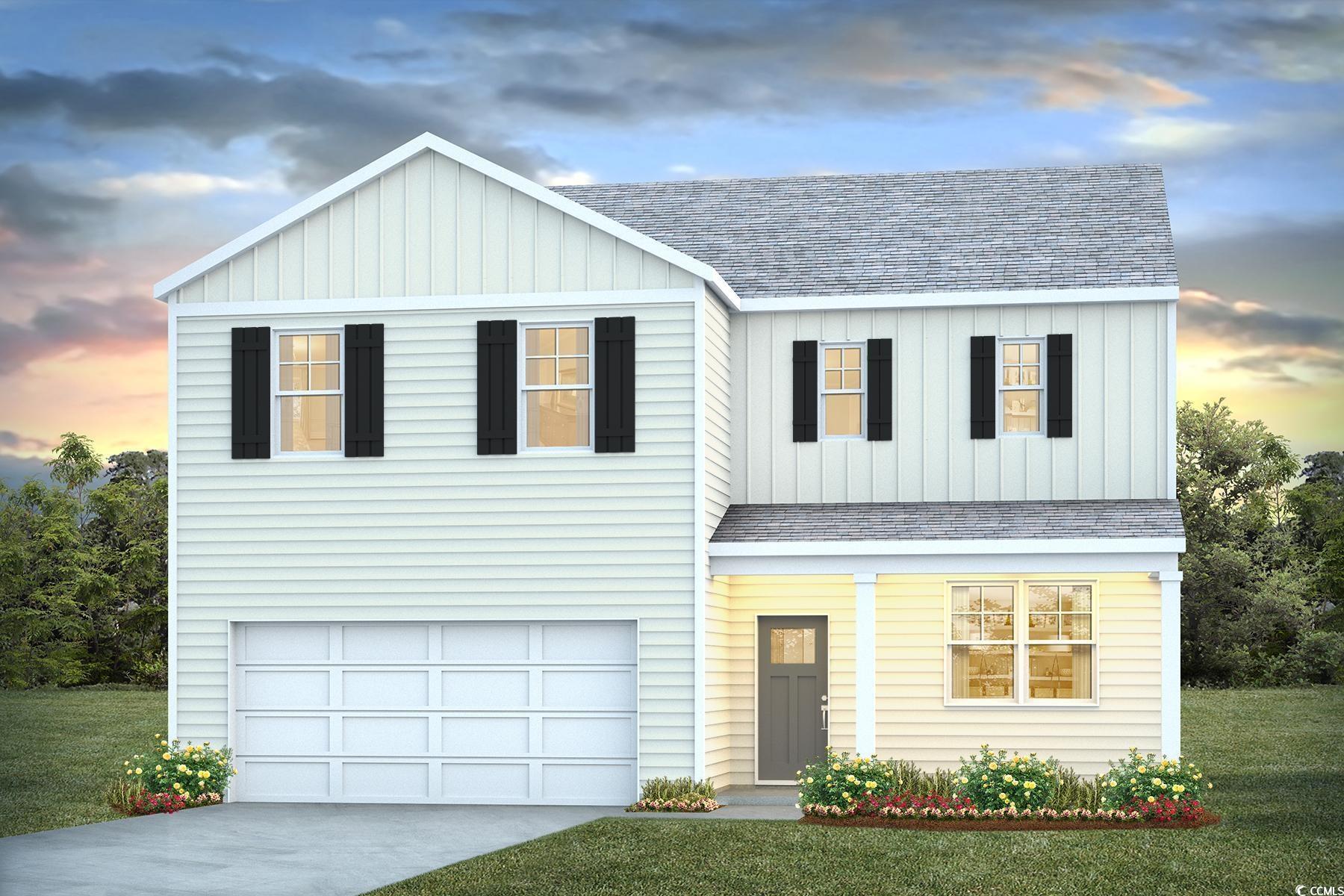 View of front of house with a yard and a garage