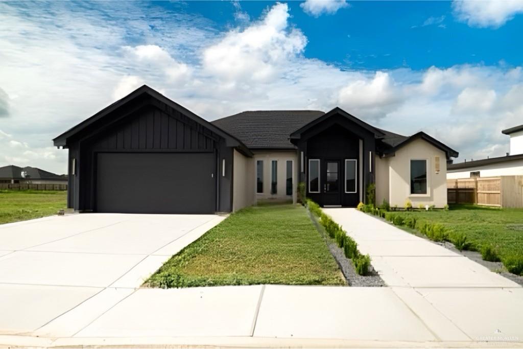 View of front facade with a garage and a front lawn