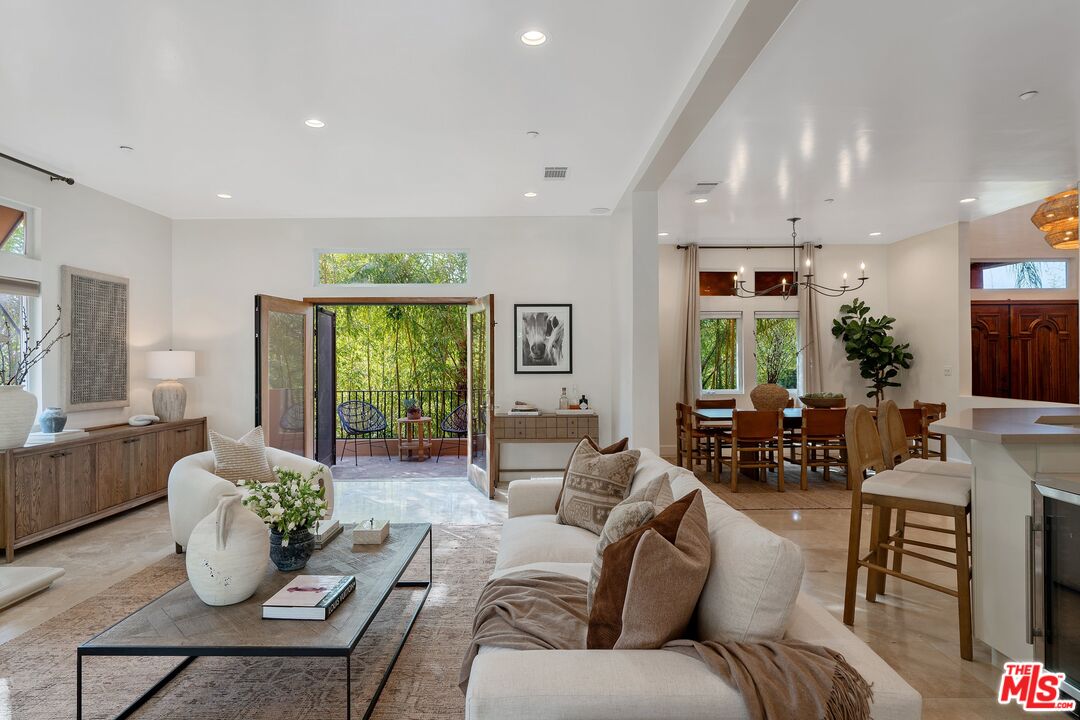 a living room with furniture potted plant and a large window