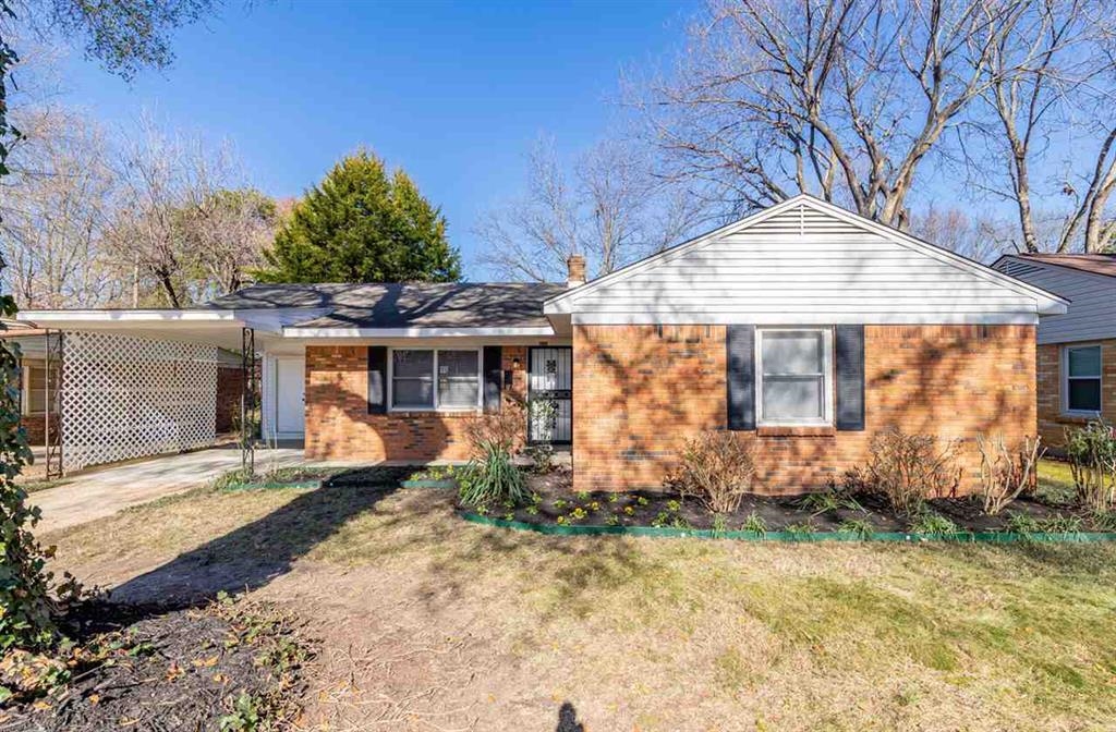 Ranch-style house with a front lawn and a carport