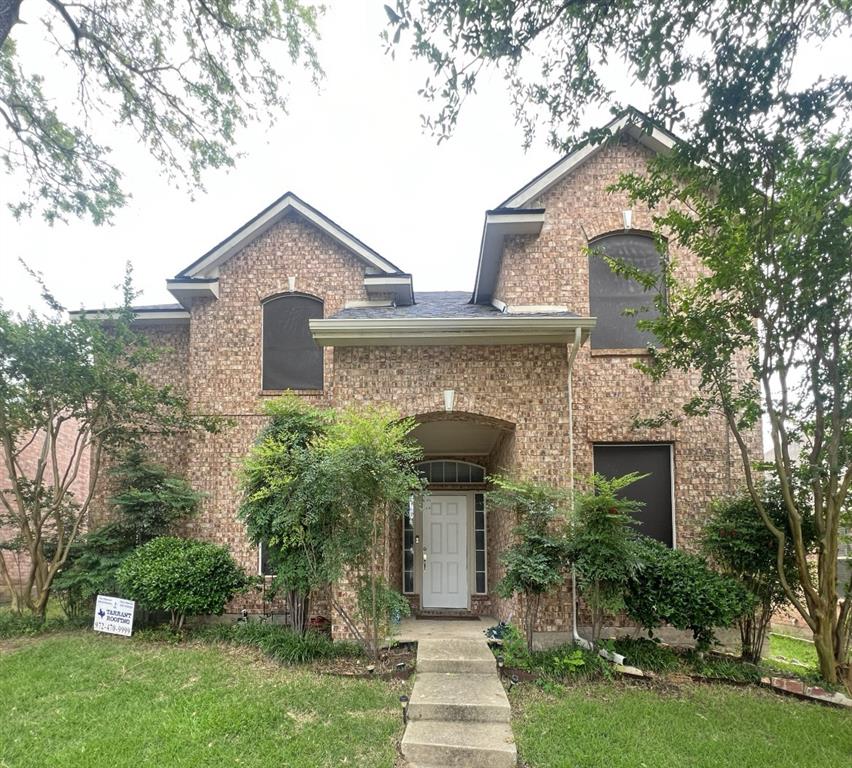 front view of a house with a yard and an trees