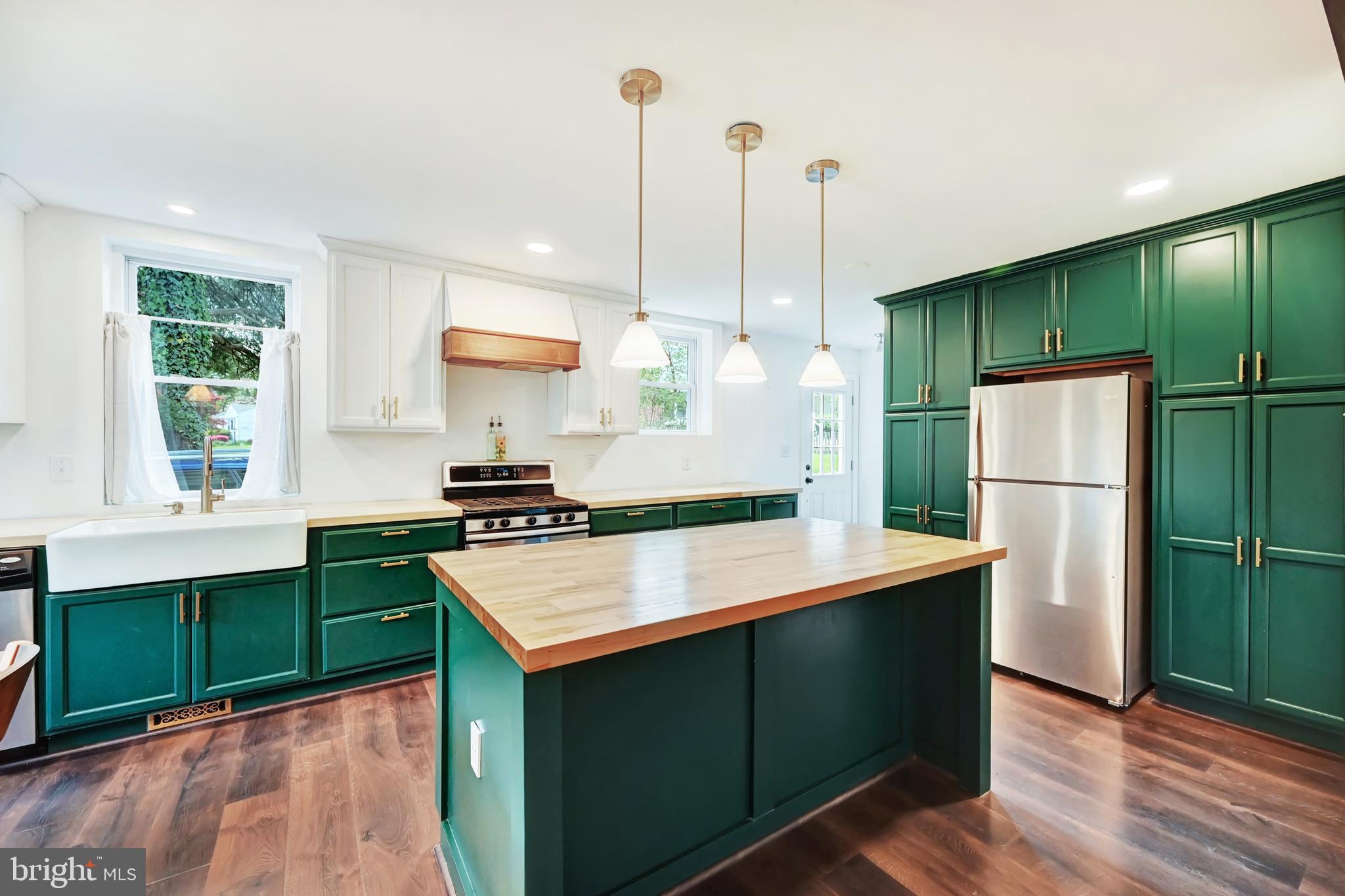 a kitchen with kitchen island white cabinets and stainless steel appliances