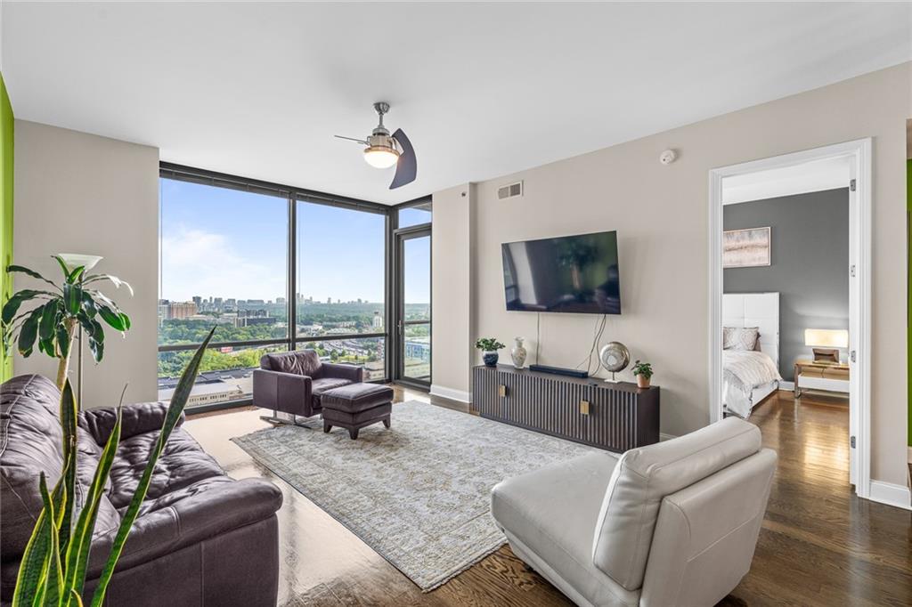 a living room with furniture large window and flat screen tv