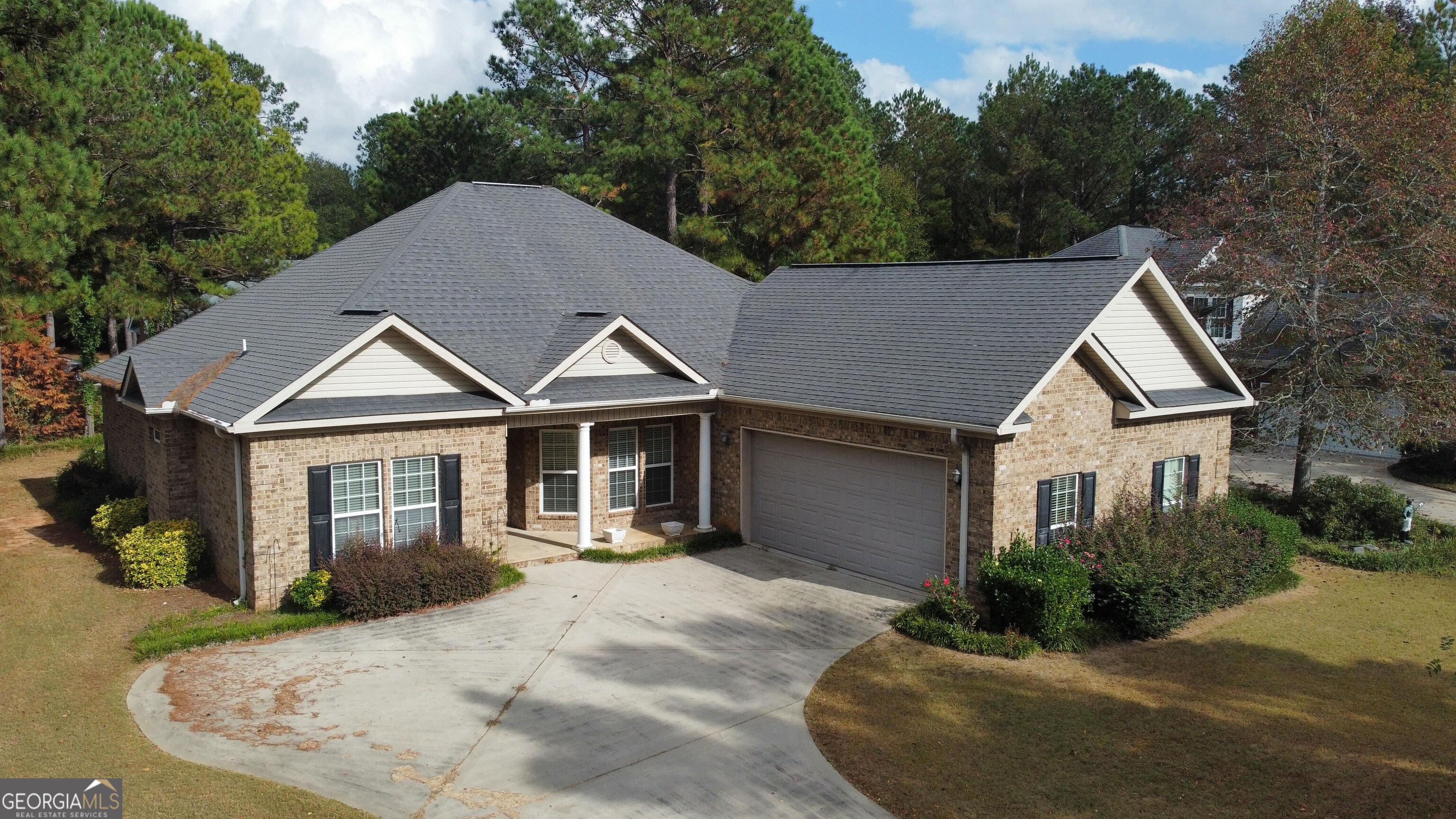 a view of house with yard and trees in the background