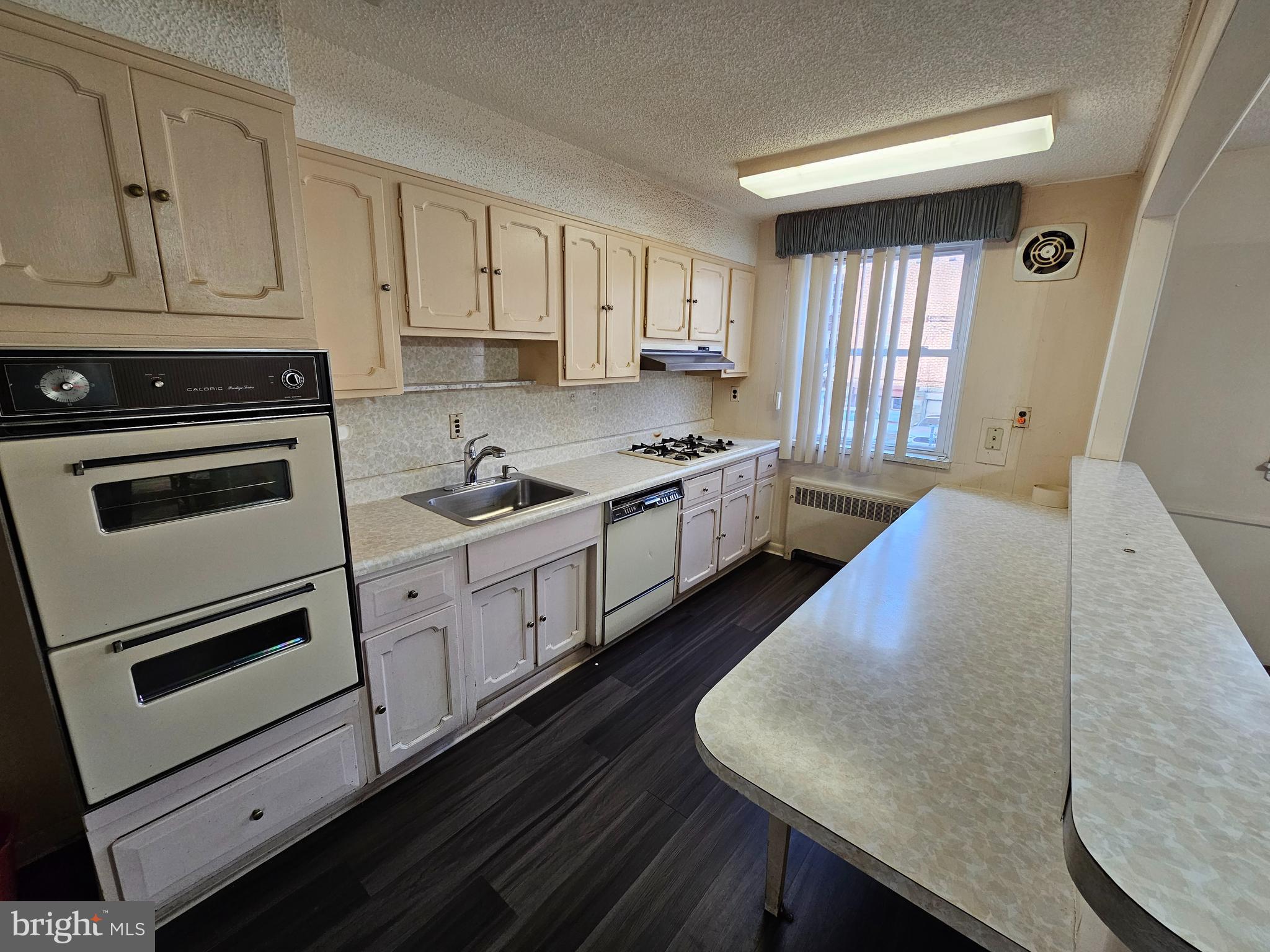 a kitchen with granite countertop white cabinets and white appliances