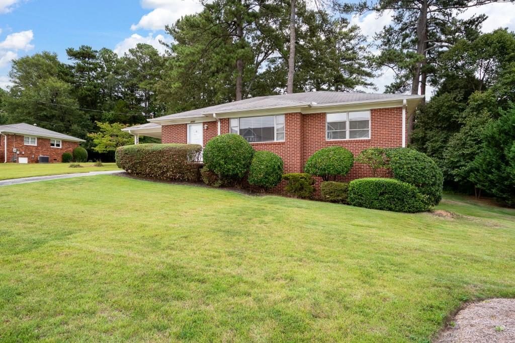 a view of a house with a yard and potted plants