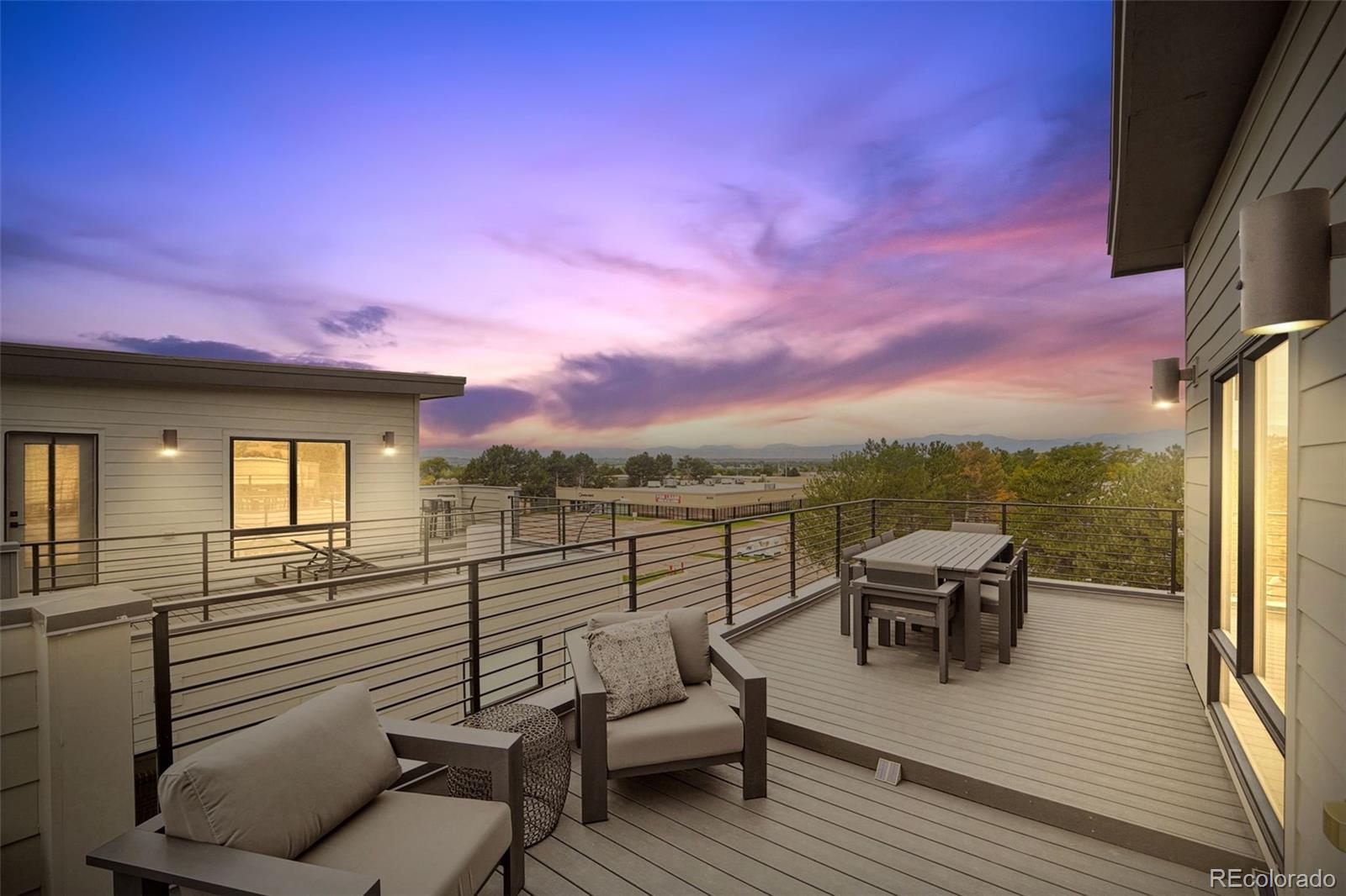 a view of a roof deck with couches and wooden floor