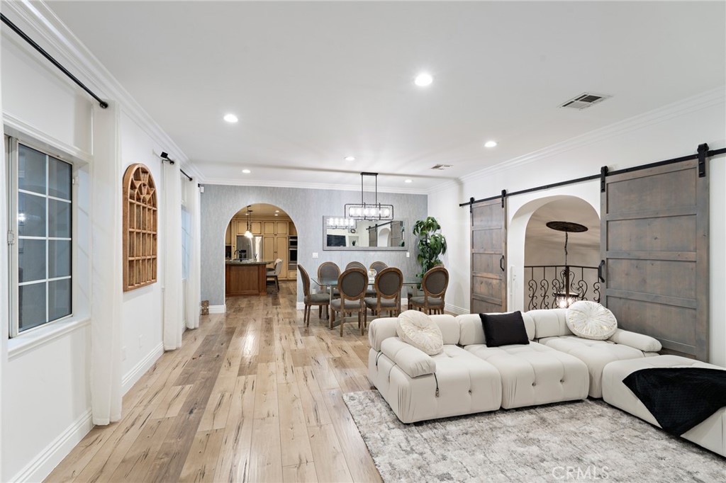 a living room with furniture a chandelier and wooden floor