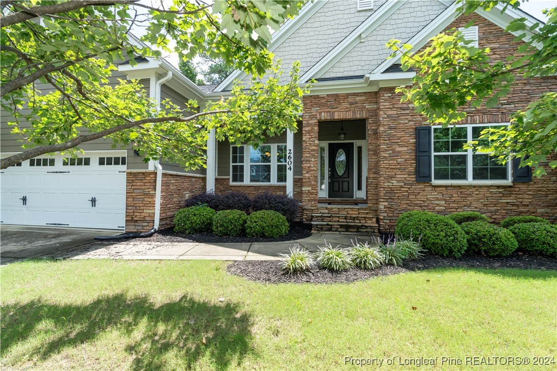 a view of a house with a yard and potted plants