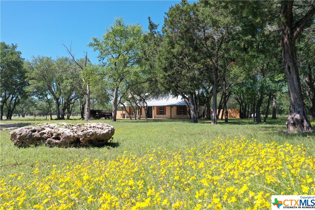 a front view of a house with a garden and trees