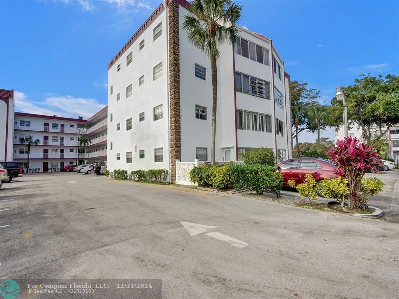 a front view of a multi story residential apartment building with a yard and entertaining space