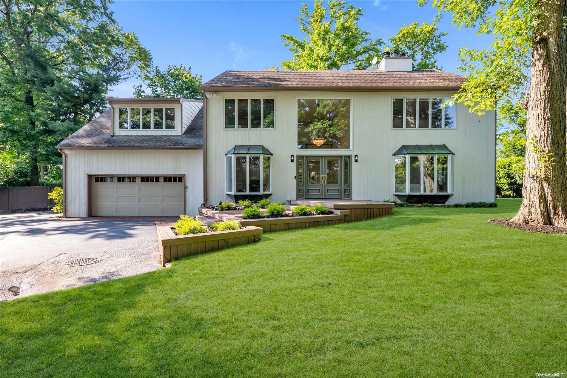 a front view of a house with a yard and trees