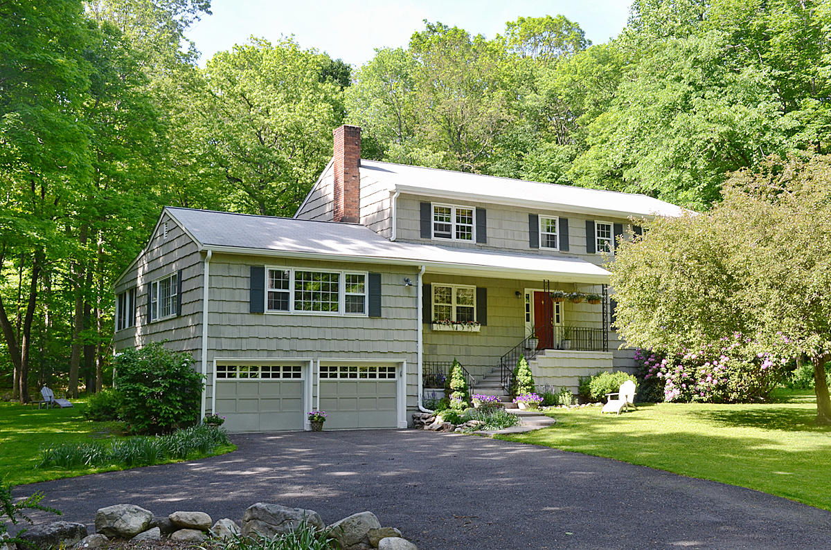 a front view of a house with a yard and trees