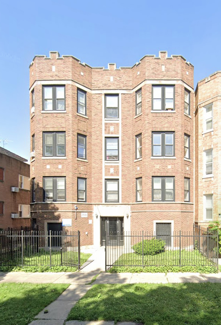 a front view of a residential apartment building with a yard