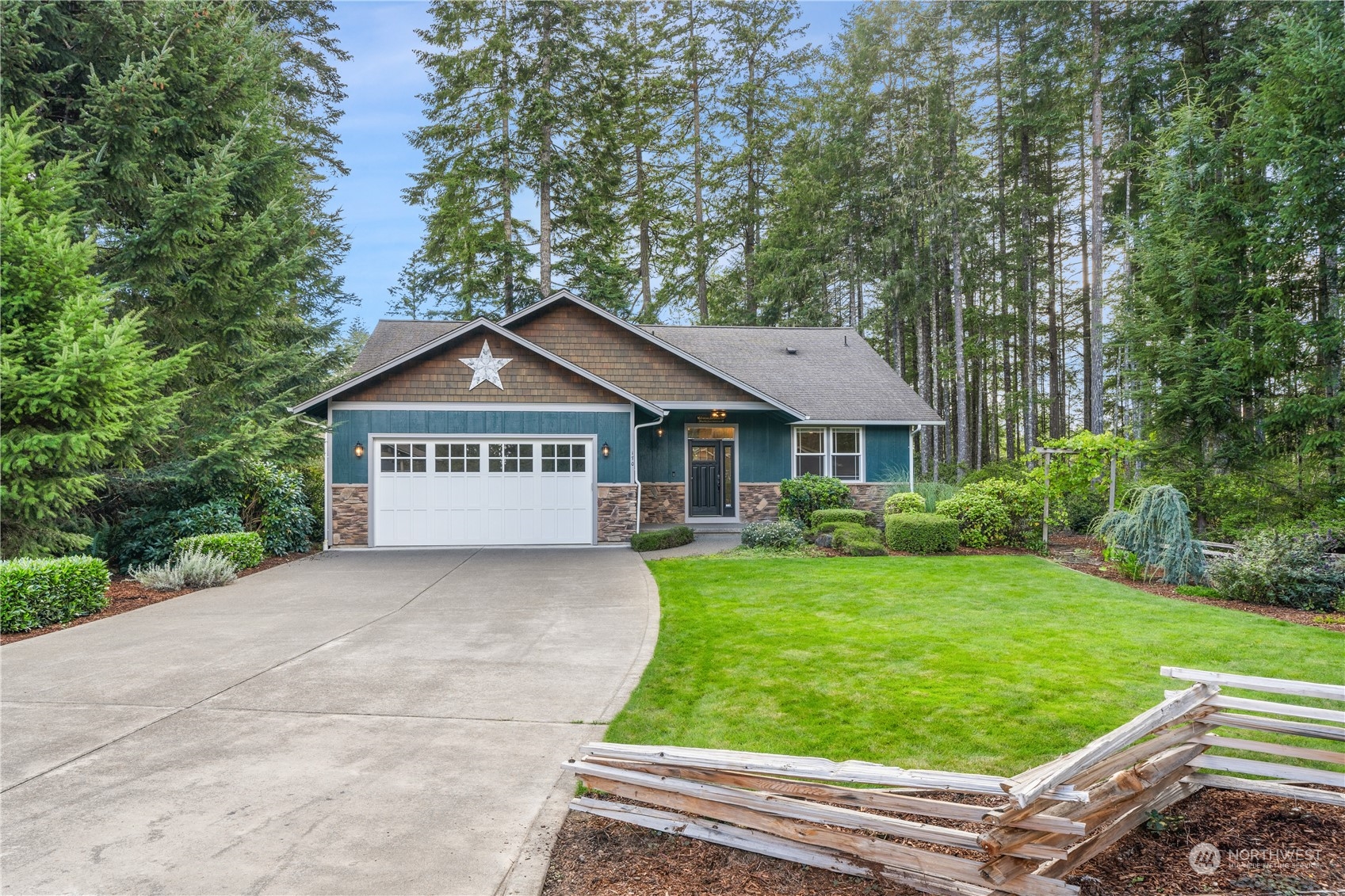 a view of a house with a yard plants and large tree