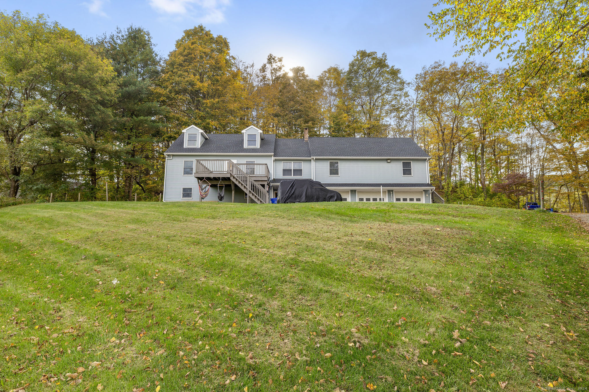 a view of a house with a big yard and large trees