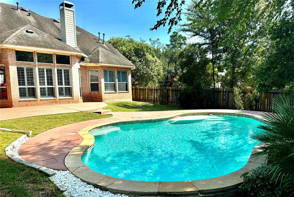 a swimming pool with outdoor seating and yard