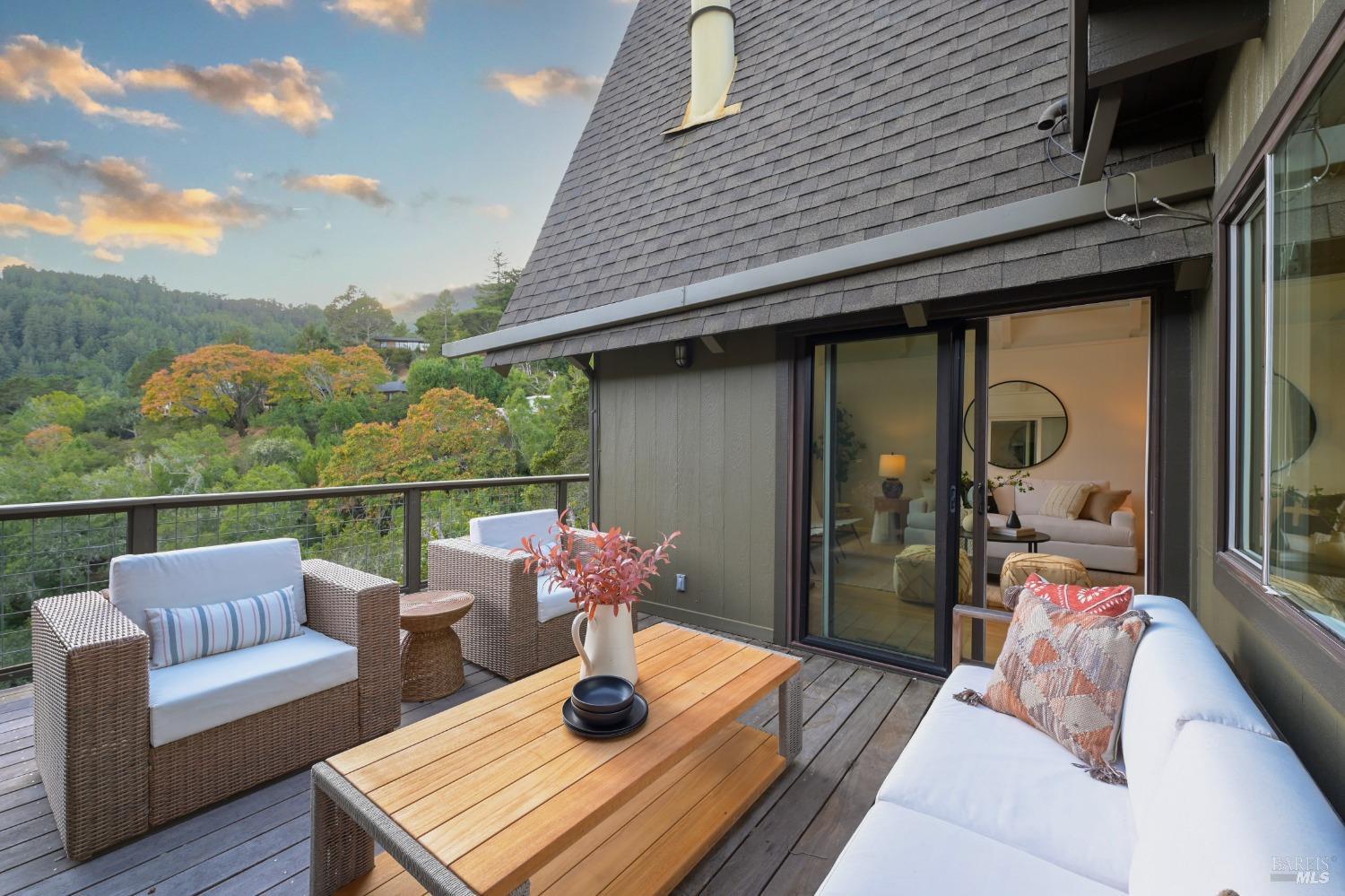 a roof deck with couches and wooden floor