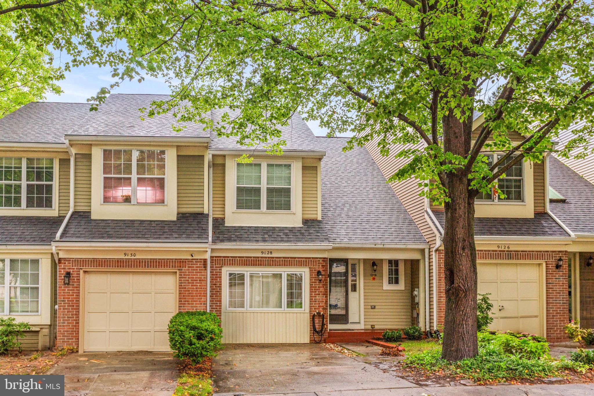 a front view of a house with a tree