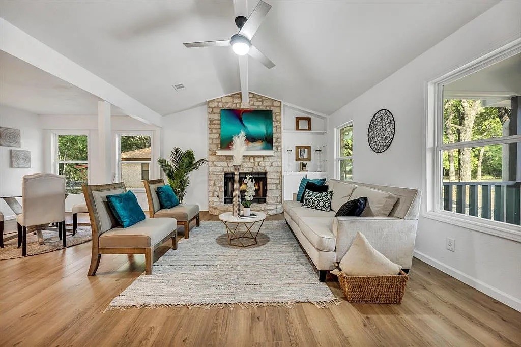 a living room with fireplace furniture and a large window