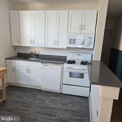 a white kitchen with granite countertop stainless steel appliances