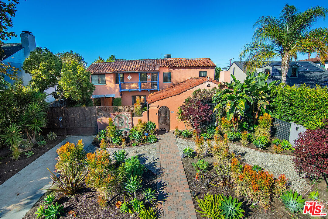 a front view of a house with a yard and potted plants