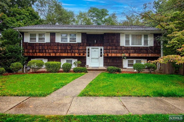 a front view of a house with a garden and yard