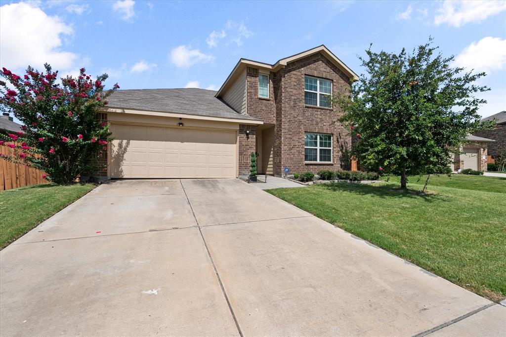 a front view of a house with a yard and trees