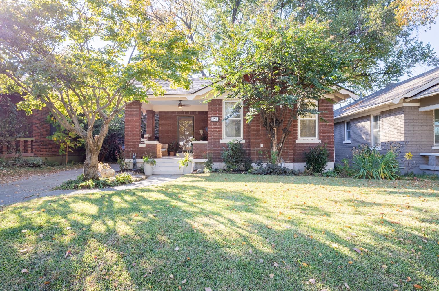 a view of a house with a tree in the yard